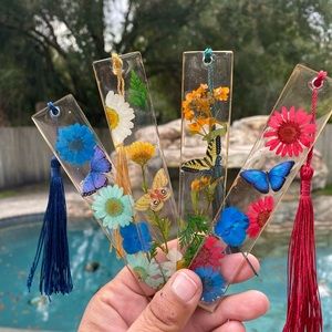 One Handmade resin 5.5” glitter bookmarks and pressed floral designs.